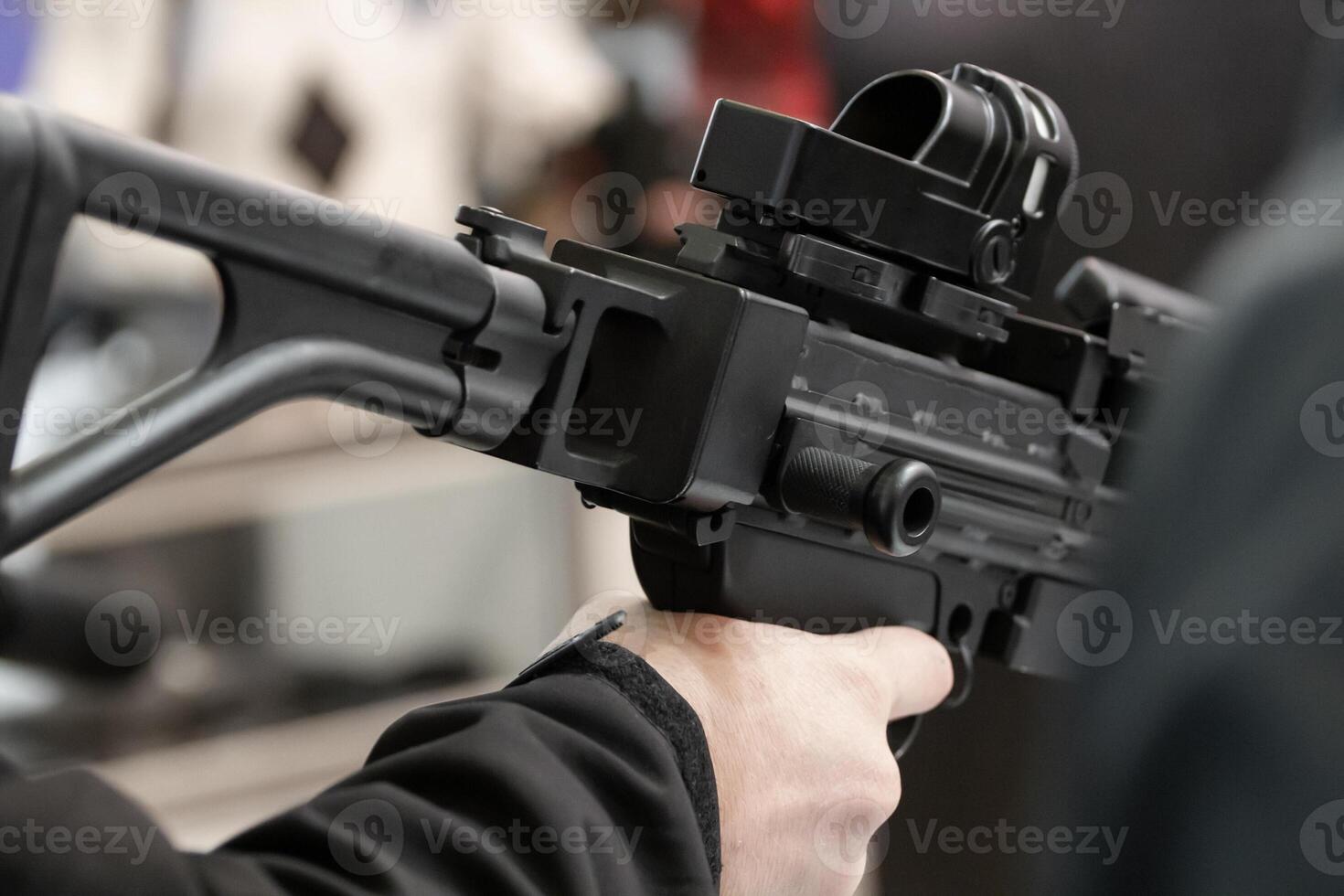 Mens choose guns on stands with weapons. Weapon stand at an arms exhibition. photo