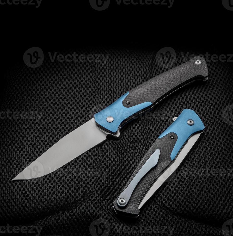 Folding pocket knife with a clip on a dark back. Handle with carbon and color inserts. photo
