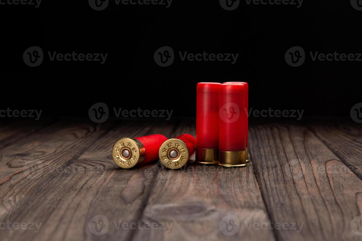 Shotgun cartridges on a brown wooden table. Ammunition for 12 gauge smoothbore weapons. photo