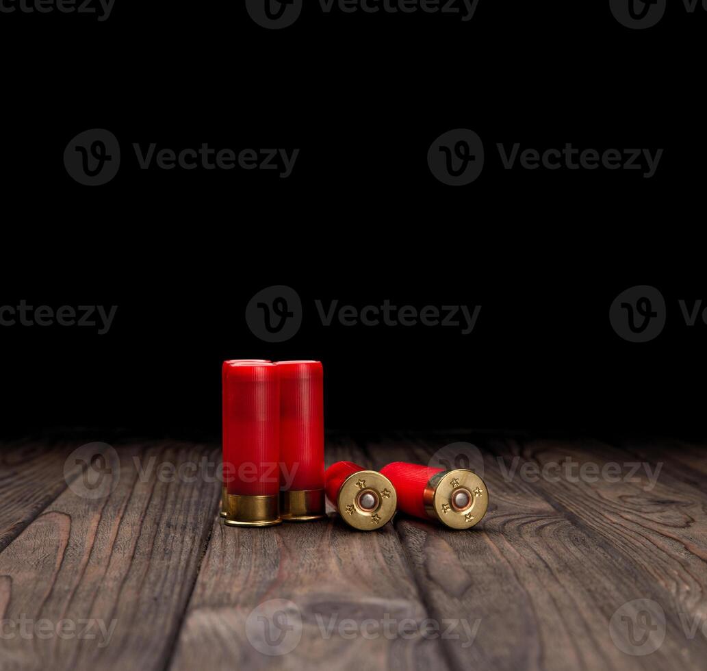 Shotgun cartridges on a brown wooden table. Ammunition for 12 gauge smoothbore weapons. photo
