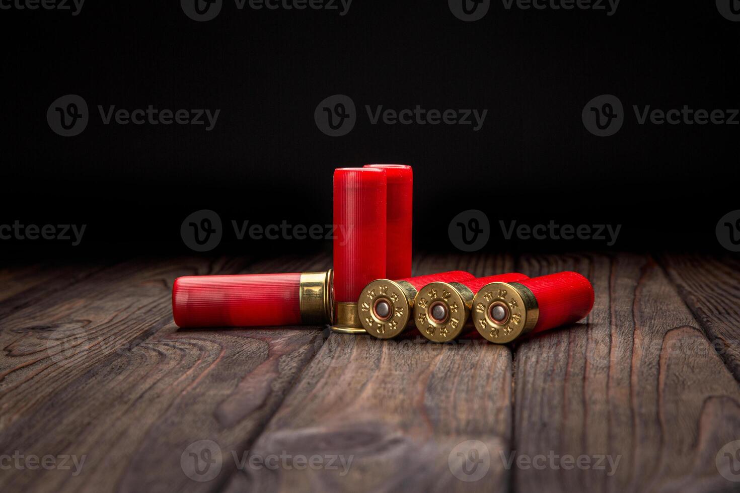 Shotgun cartridges on a brown wooden table. Ammunition for 12 gauge smoothbore weapons. Hunting ammunition. photo