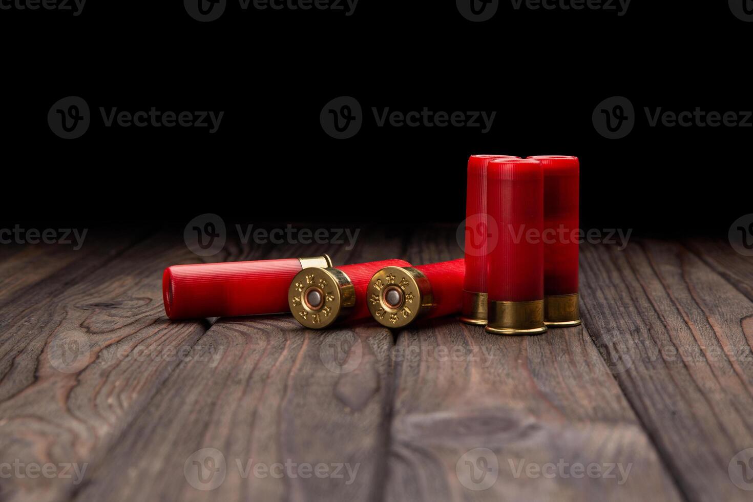 Shotgun cartridges on a brown wooden table. Ammunition for 12 gauge smoothbore weapons. photo