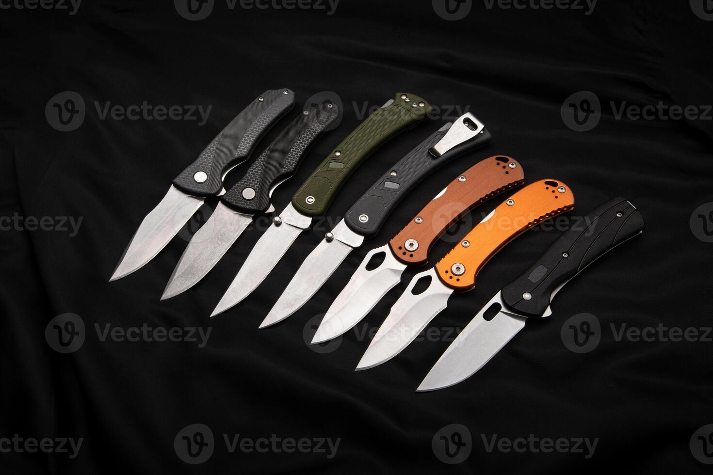 Various folding pocket knives on a dark back. A versatile pocket tool and self-defense tool. photo
