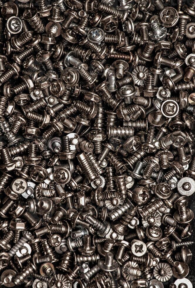 A background of silver screws and bolts. Various screws. Hardware photo