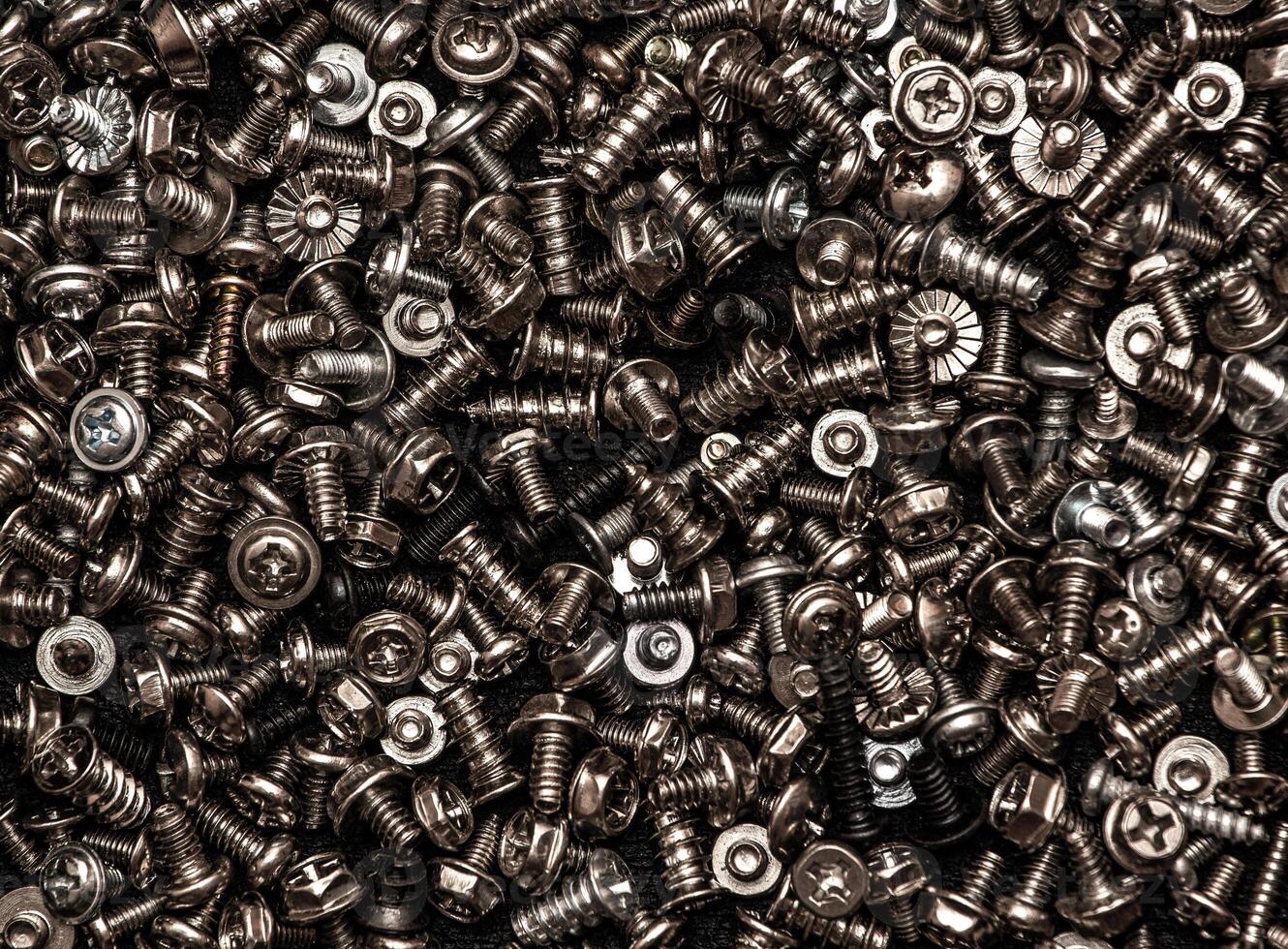 A background of silver screws and bolts. Various screws. Hardware photo