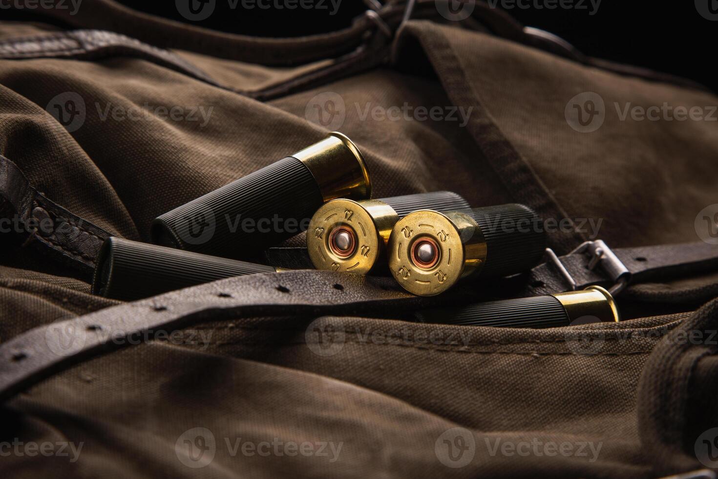 Shotgun shells close-up. Ammunition for smoothbore weapons on a khaki canvas backpack. Dark back photo