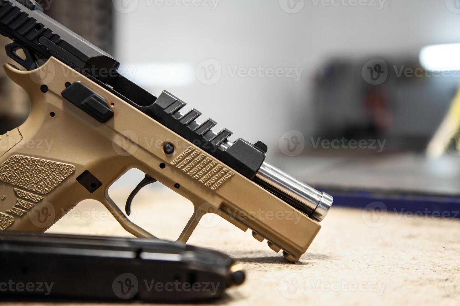 Modern black-brown traumatic pistol on the table. Unloaded weapon for self-defense in a safe condition photo