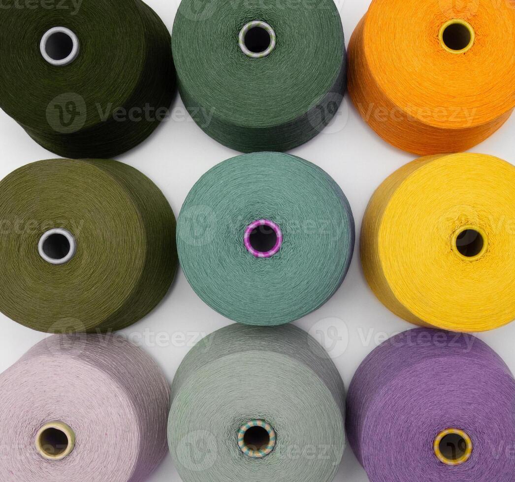 Multi-colored bobbins of yarn on a white background. Top view on colored spools of thread.Textile reels on white background. photo
