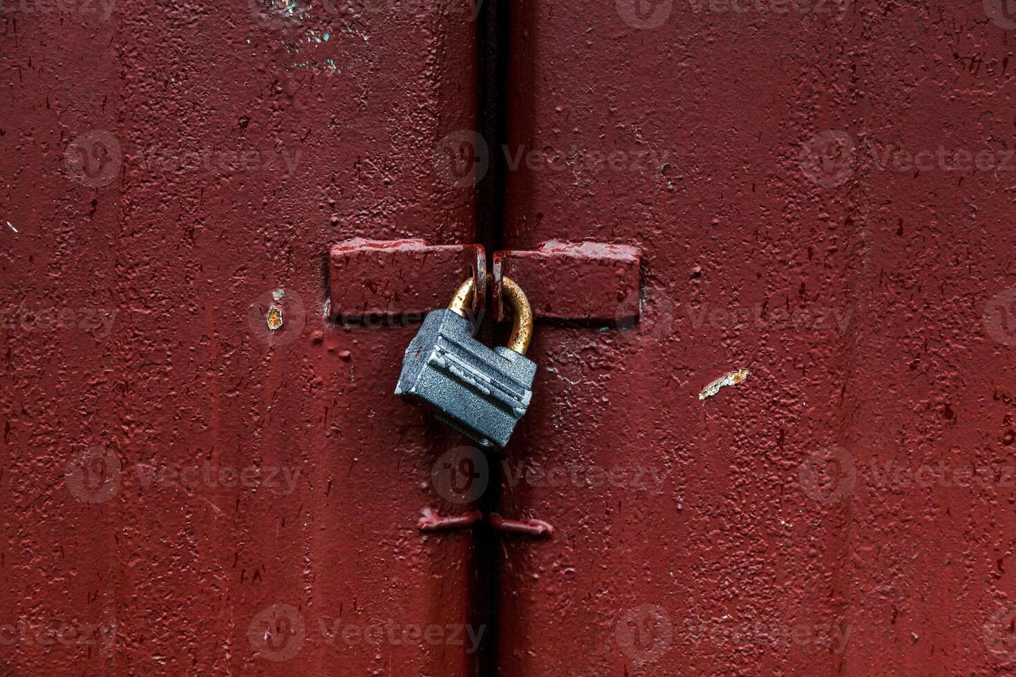 Padlock on red metal door photo