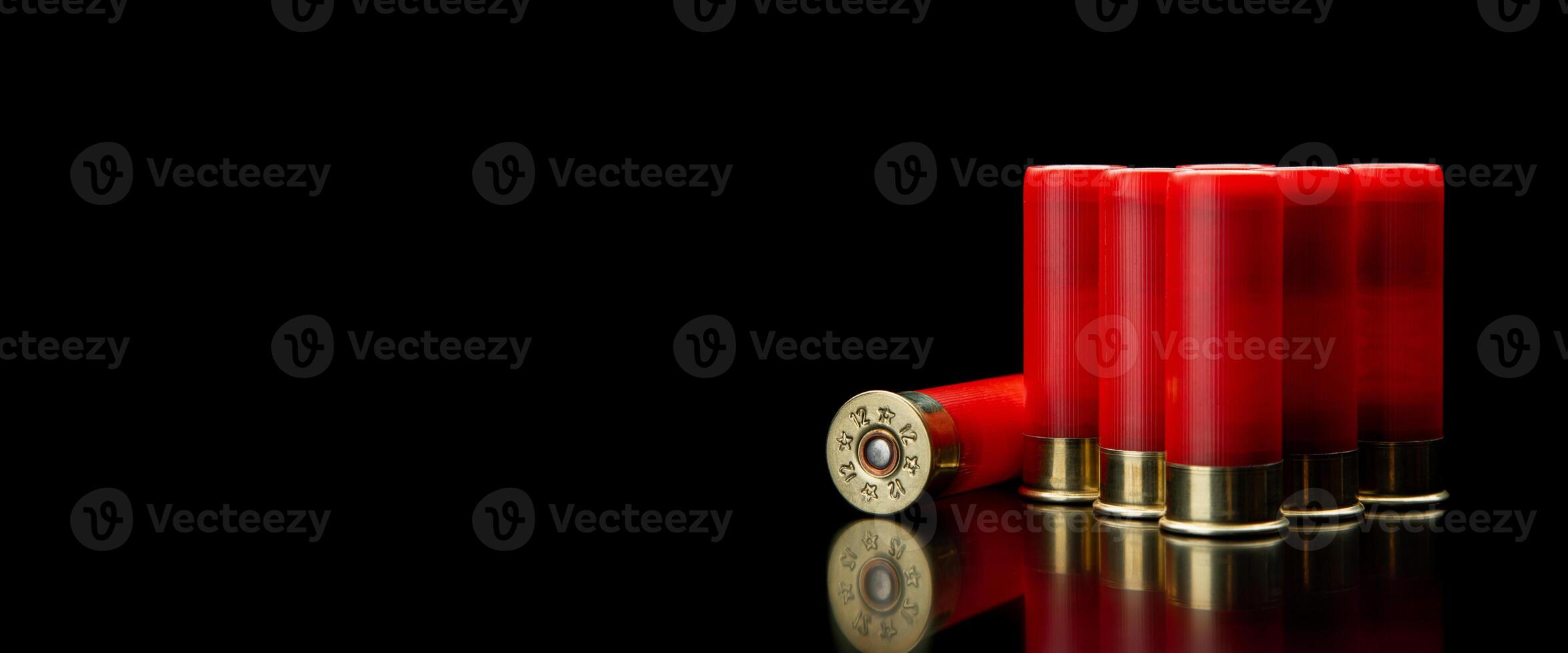 Shotgun shells on a black reflective surface. Ammunition for 12 gauge smoothbore weapons. Hunting ammunition. Dark back. photo