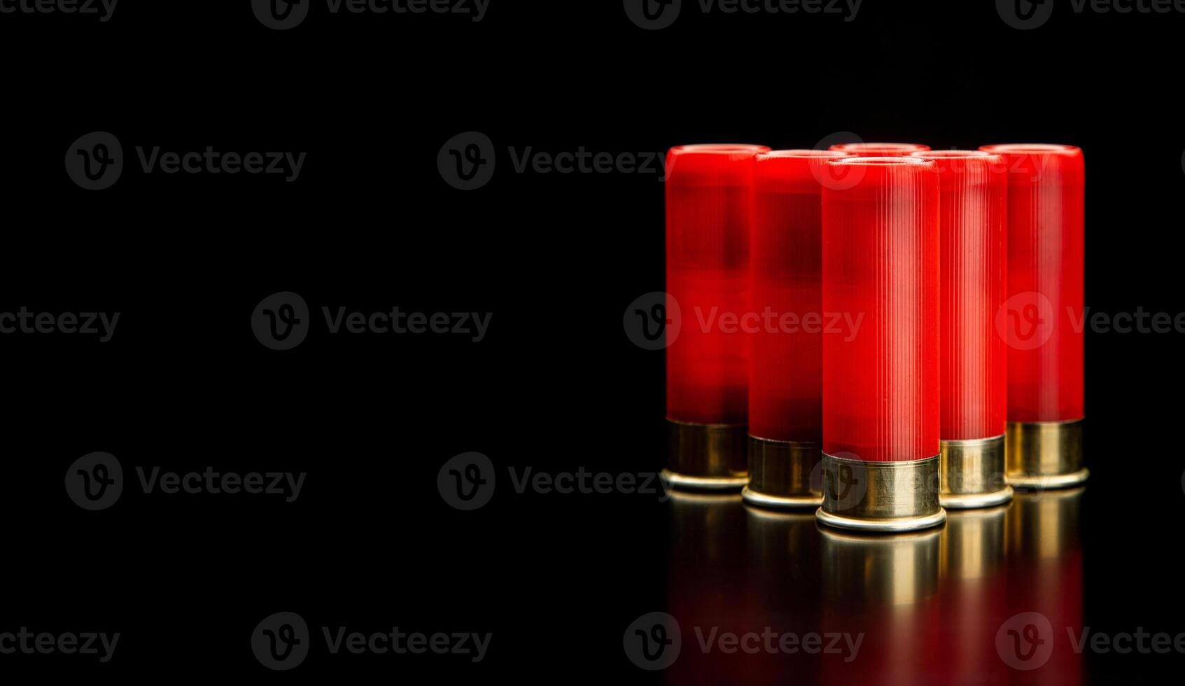 Shotgun shells on a black reflective surface. Ammunition for 12 gauge smoothbore weapons. Hunting ammunition. Dark back. photo