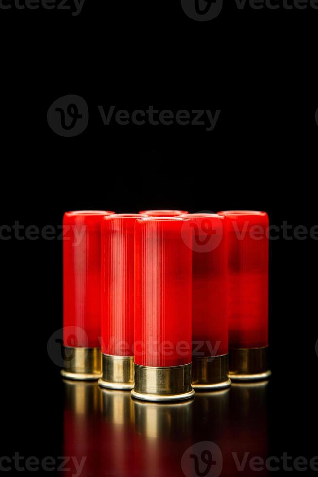 Shotgun shells on a black reflective surface. Ammunition for 12 gauge smoothbore weapons. Hunting ammunition. Dark back. photo