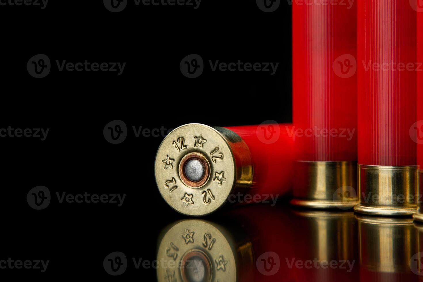 Shotgun shells on a black reflective surface. Ammunition for 12 gauge smoothbore weapons. Hunting ammunition. Dark back. photo