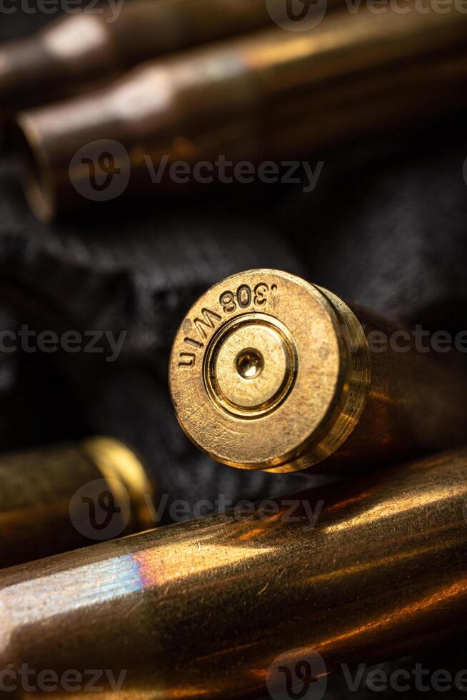 Empty shells from weapons on black smoldering coals. Consequences of the war. Dark back. photo