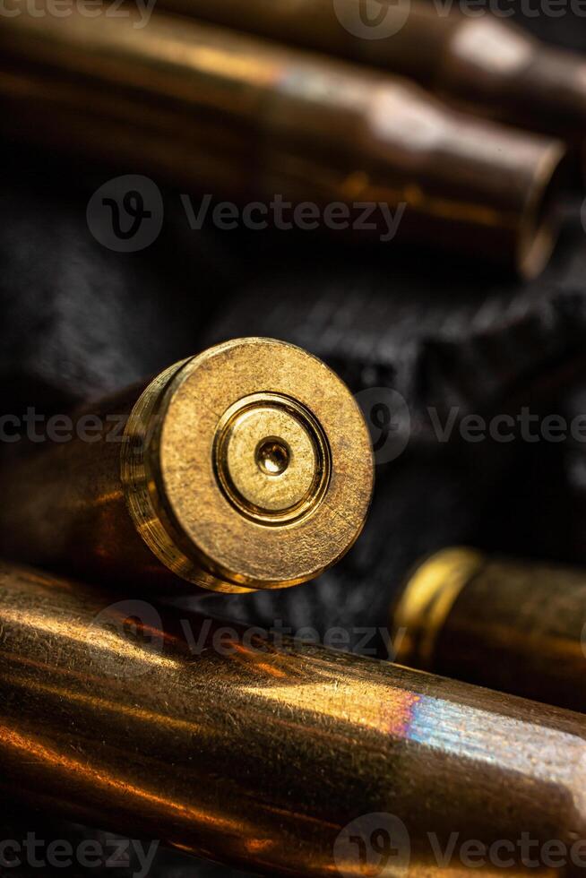 Empty shells from weapons on black smoldering coals. Consequences of the war. Dark back. photo