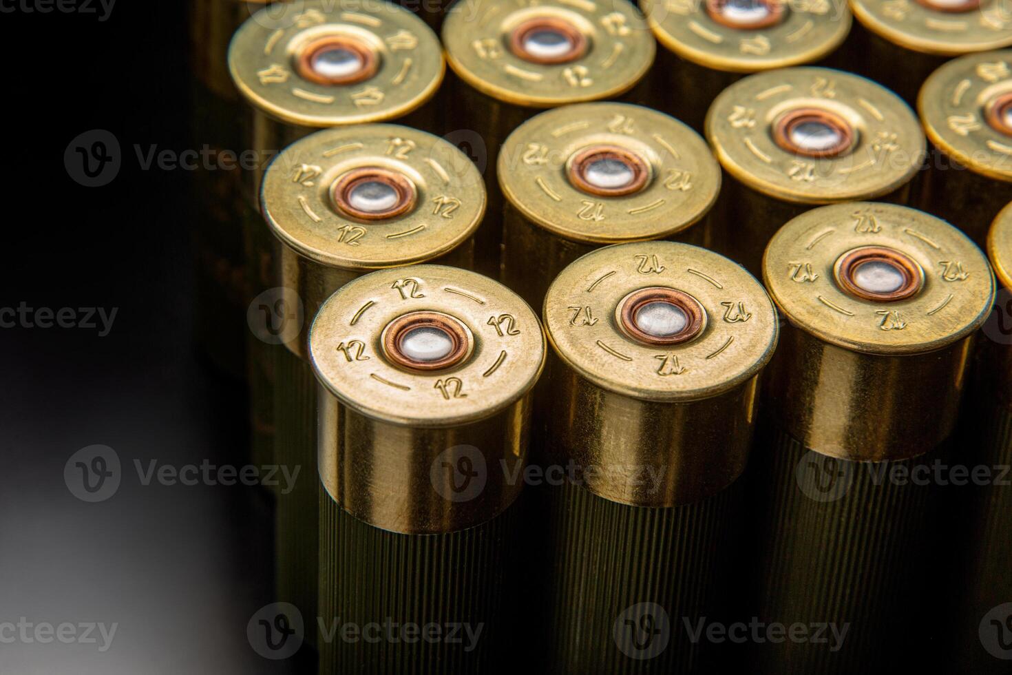 Shotgun shells on a black reflective surface. Ammunition for 12 gauge smoothbore weapons. Hunting ammunition. Dark back. photo