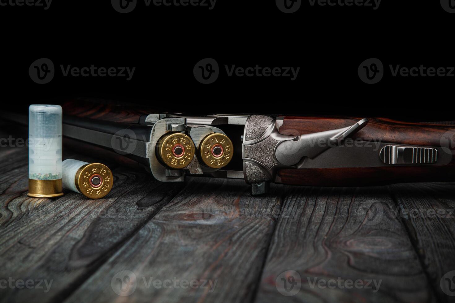 Classic trigger double-barreled hunting rifle on a wooden background. Concept postcards for hunters. Smooth-bore hunting rifle open for reloading. photo