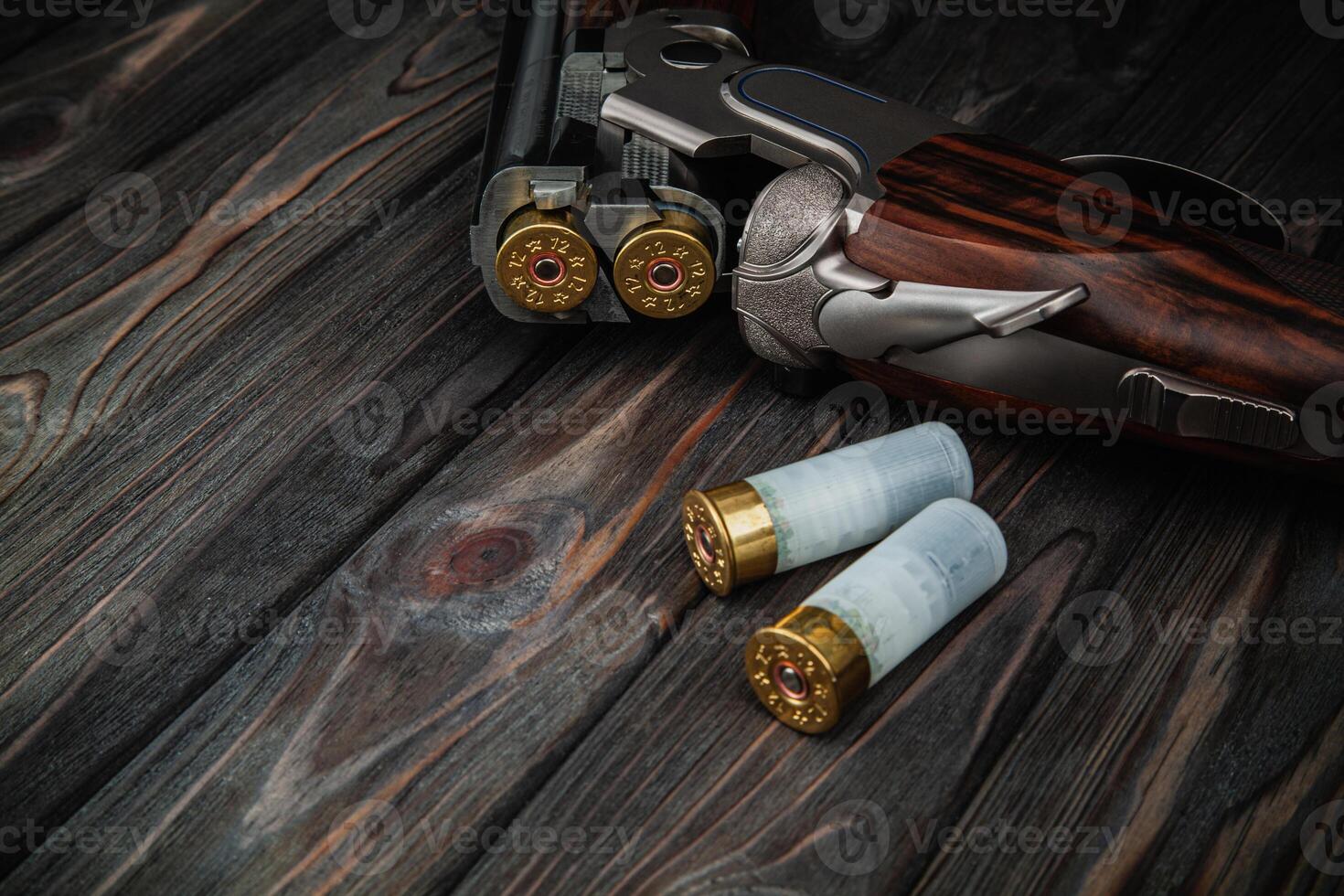 Classic trigger double-barreled hunting rifle on a wooden background. Concept postcards for hunters. Smooth-bore hunting rifle open for reloading. photo