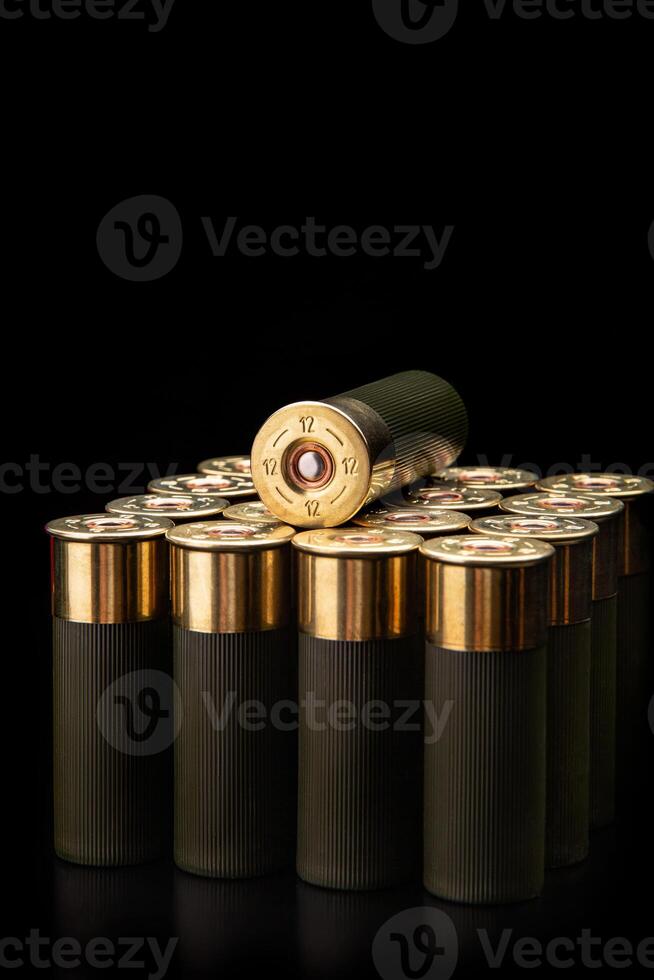 Shotgun shells on a black reflective surface. Ammunition for 12 gauge smoothbore weapons. Hunting ammunition. Dark back. photo