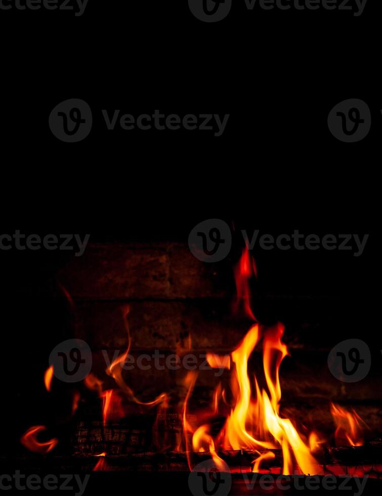 Fire on a black background. Red, orange and yellow flames and sparks on a dark background. Bonfire, fireplace, hearth or fire. photo