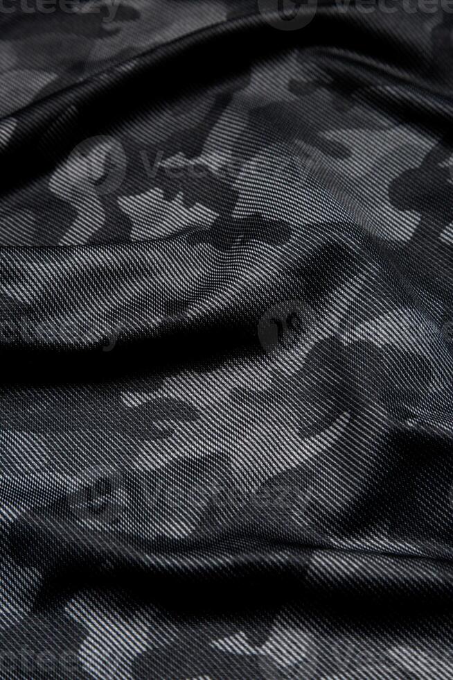 Camouflage pattern. Trendy dark gray camouflage fabric. Military texture. Dark back. photo