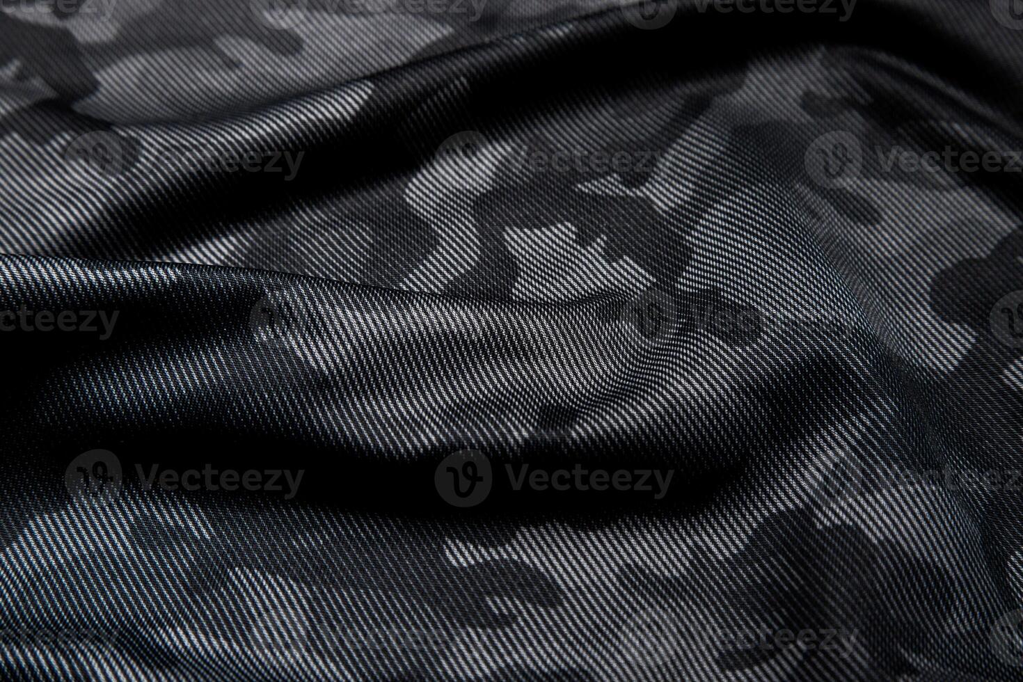 Camouflage pattern. Trendy dark gray camouflage fabric. Military texture. Dark back. photo