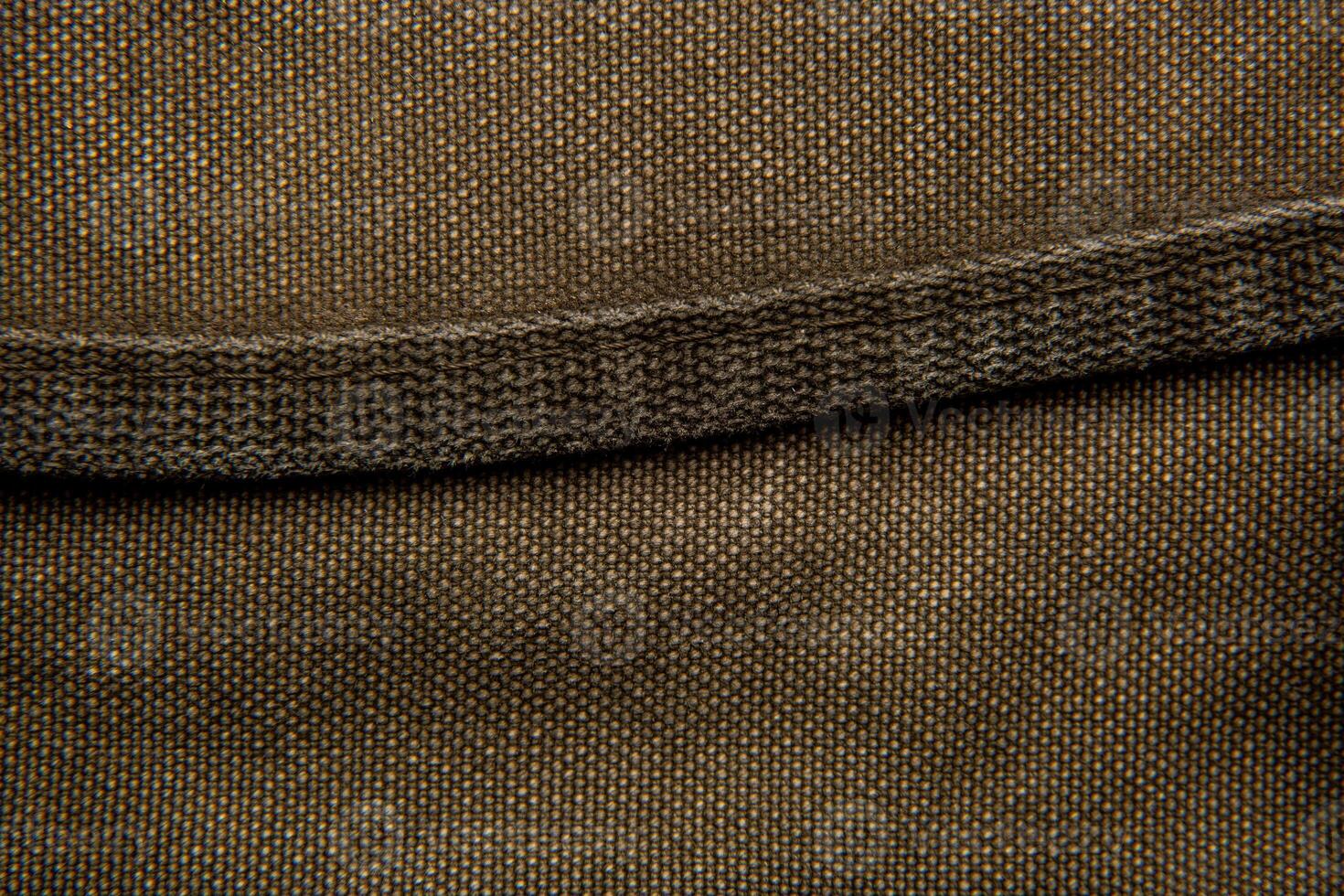 Close-up texture of a canvas fabric backpack. Leather straps and metal buckles. Vintage khaki back. photo
