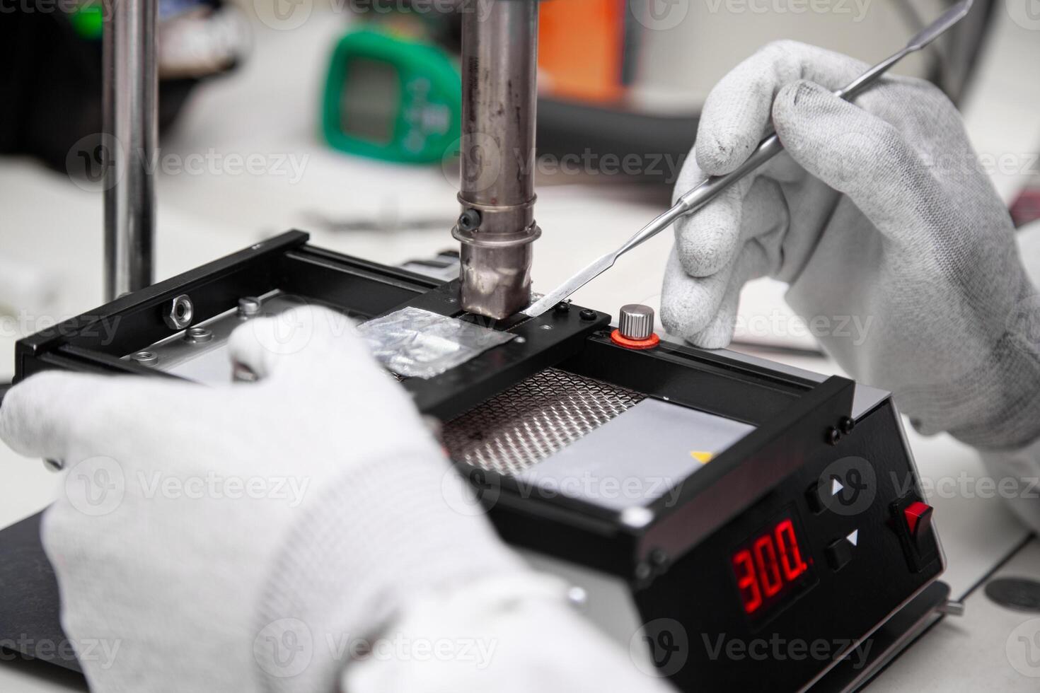 The master solders the microchip at the soldering station. Service center. Repair of microelectronics. photo