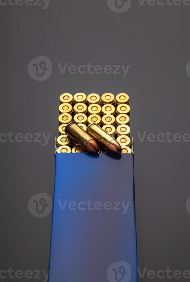 A box of cartridges for a pistol. Ammunition for weapons. Isolate on a dark back. photo