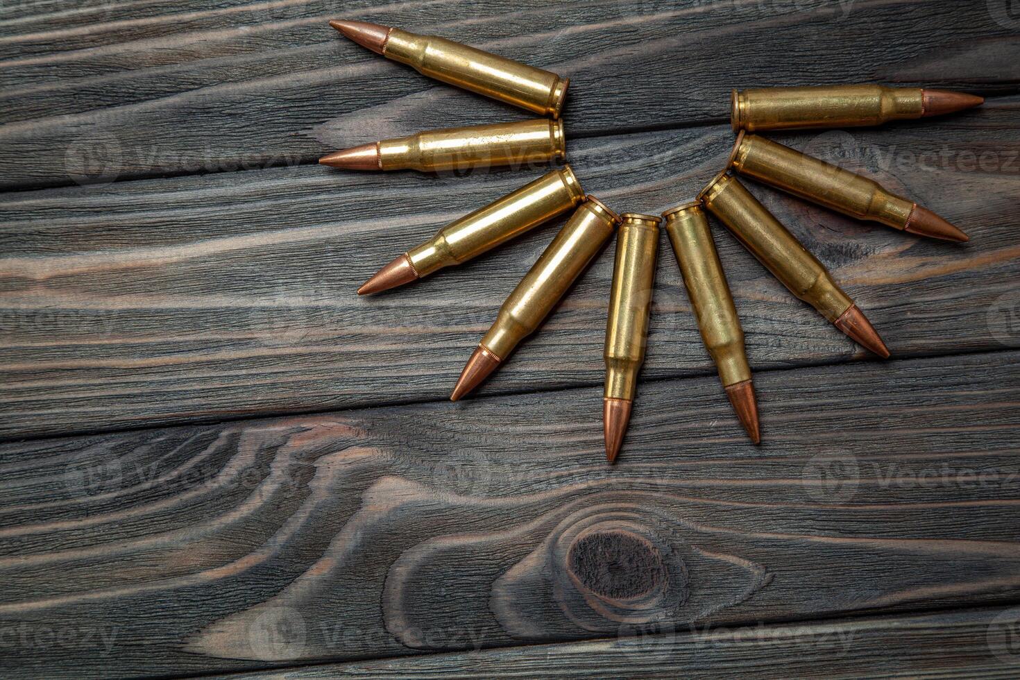 Rifle cartridges on a dark wooden back photo
