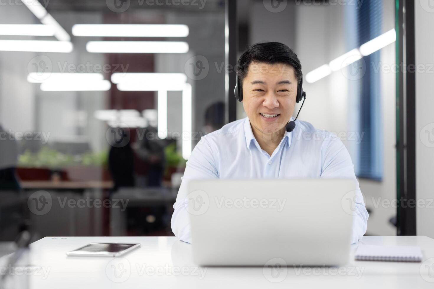 Man with headset phone close-up at workplace inside office, Asian in shirt customer service worker, businessman using laptop for call, and customer consultation, telephone sales, photo