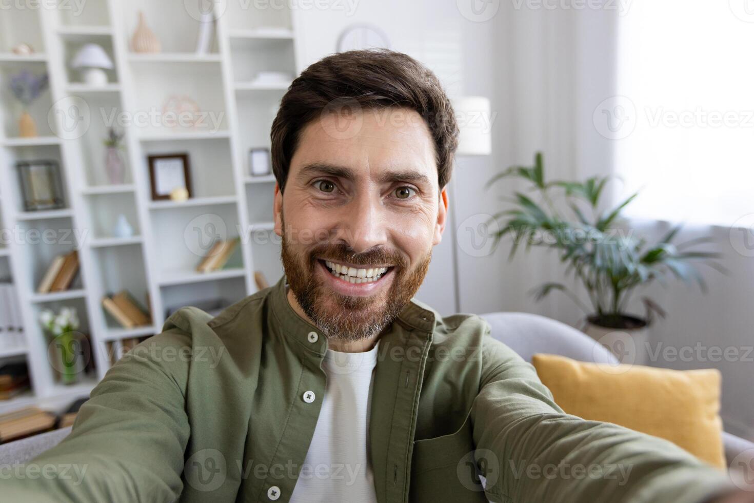 First person view of happy caucasian male in shirt recording on digital camera. Popular influencer producing content fro new post in social median and new post in personal blog from home. photo
