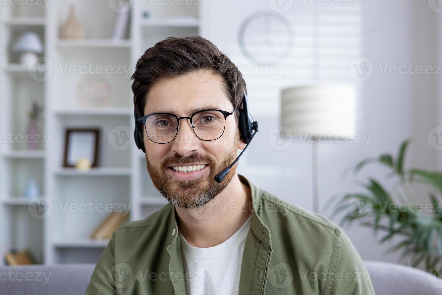 Smiling man with headset engaged in a virtual meeting from his modern home office. Business and technology concept. photo