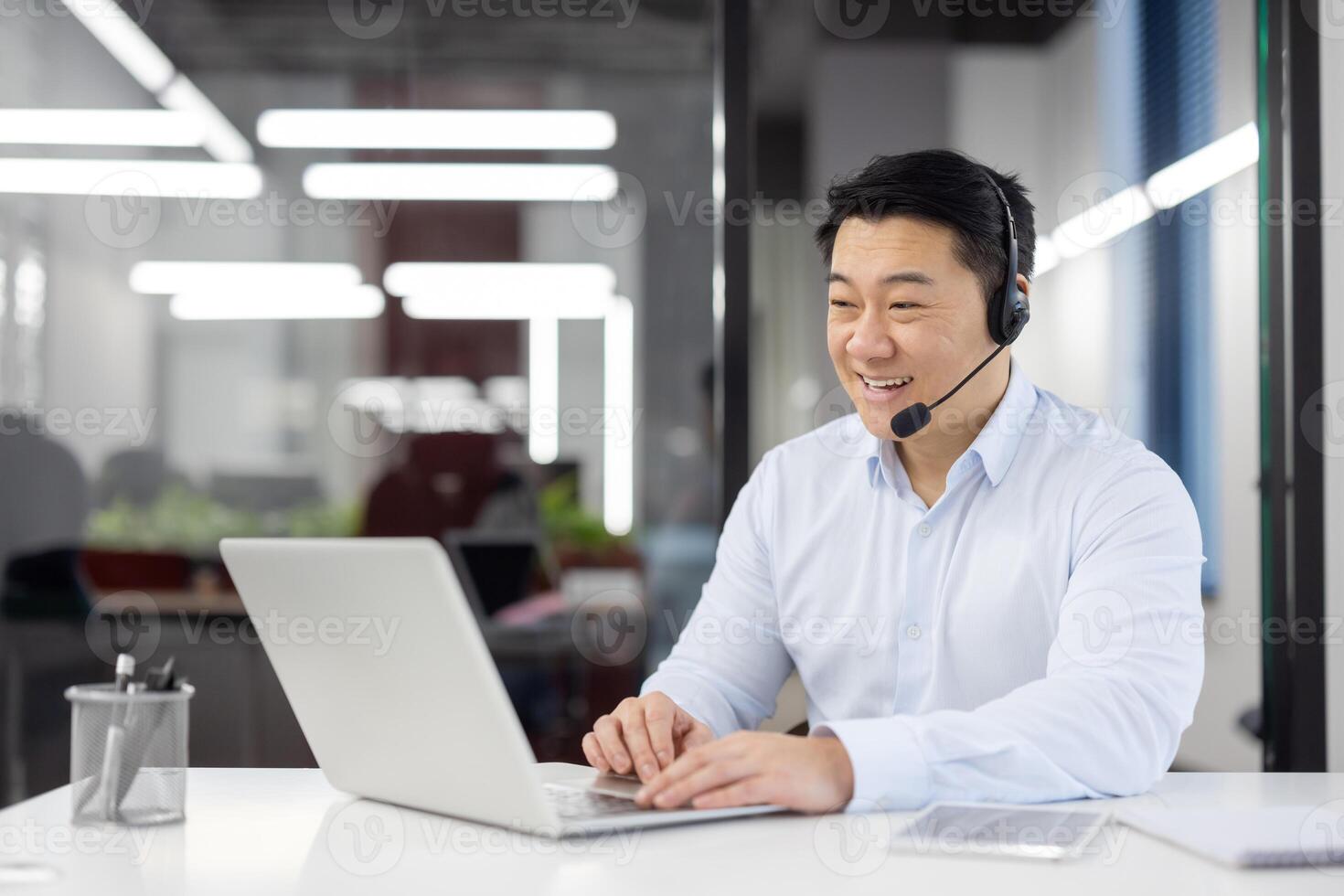Man with headset phone close-up at workplace inside office, Asian in shirt customer service worker, businessman using laptop for call, and customer consultation, telephone sales, photo