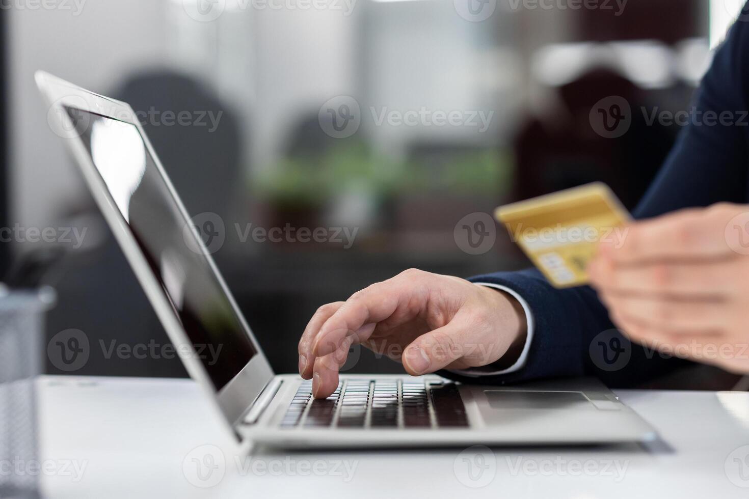 Hands of businessman close up, man with laptop and bank credit card at workplace inside office, make online purchase and money transfer remotely. photo