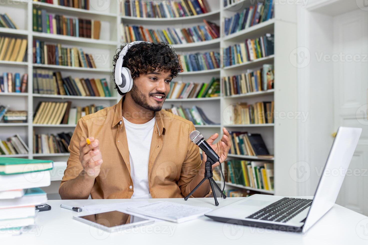A passionate student immersed in recording a podcast session, surrounded by books in a library setting, conveying a vibe of knowledge and technology. photo