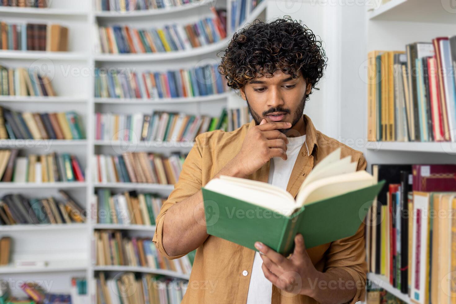 A young student stands engrossed in a large book amidst a library's diverse collection, symbolizing study and concentration. photo