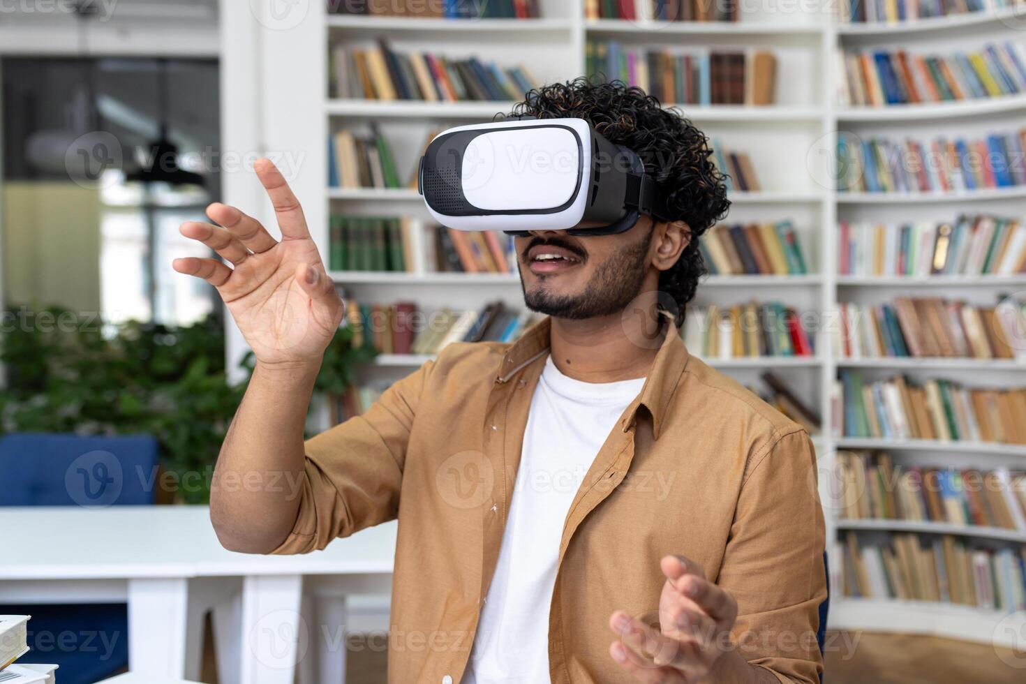 Young student close-up inside university academic library studying, man uses VR virtual reality glasses to watch course videos and online material. photo