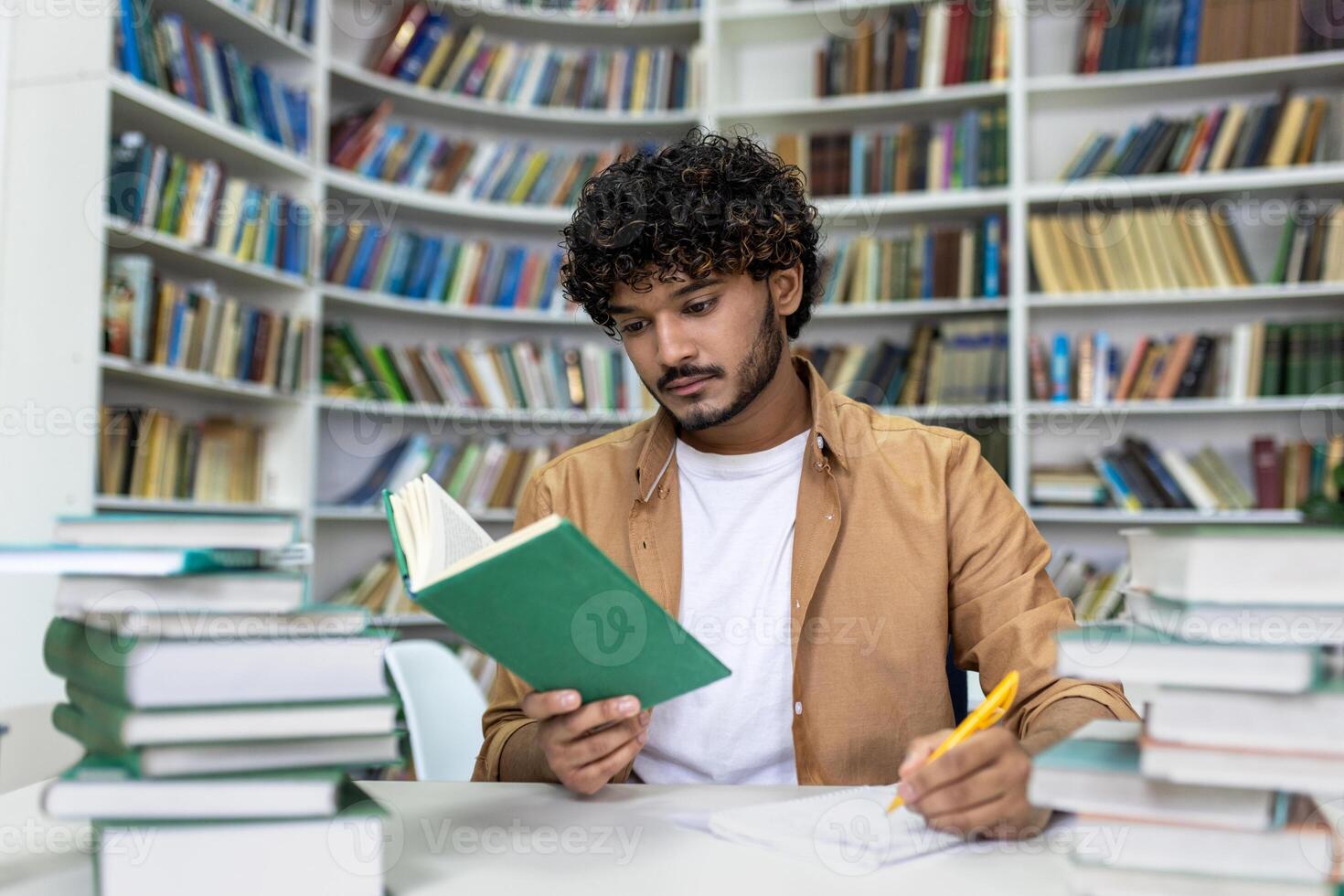 A dedicated student engrossed in reading a book, surrounded by piles of textbooks, diligently preparing for upcoming exams in the quiet atmosphere of a university library. photo