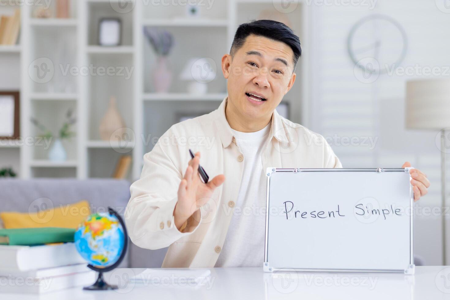Smiling teacher conducting an online class, explaining the present simple tense on a whiteboard, emphasizing grammar education. photo