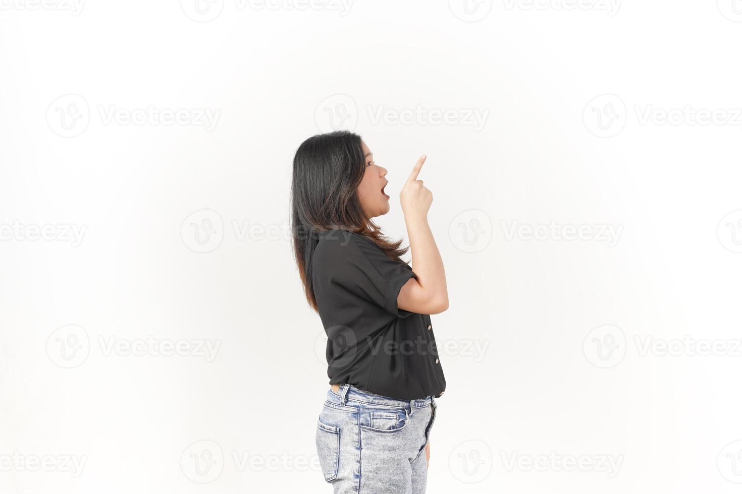 Young Asian woman showing product and pointing up copy space wearing Black t-shirt and jeans isolated on white background photo