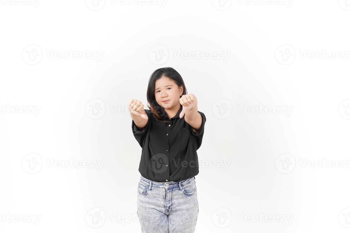 Young Asian woman showing thumbs down wearing Black t-shirt and jeans isolated on white background photo