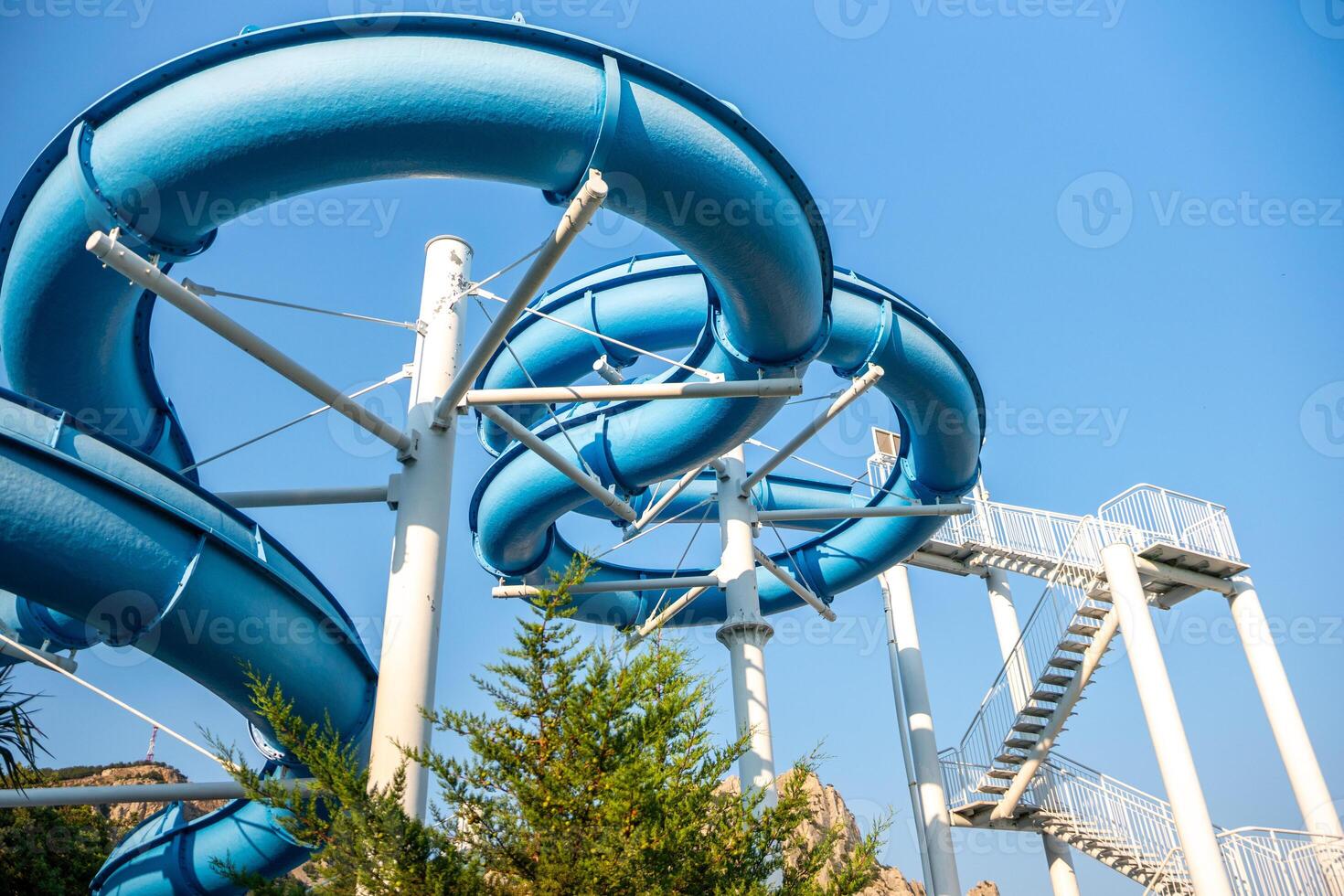 Water Slide, Amusement Park, Summer Fun - A blue water slide at an amusement park on a sunny summer day. photo