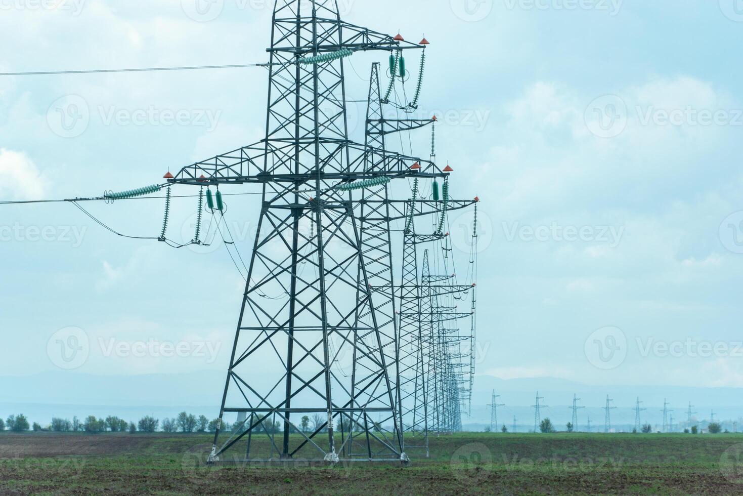High voltage towers with sky background. Power line support with wires for electricity transmission. High voltage grid tower with wire cable at distribution station. Energy industry, energy saving photo