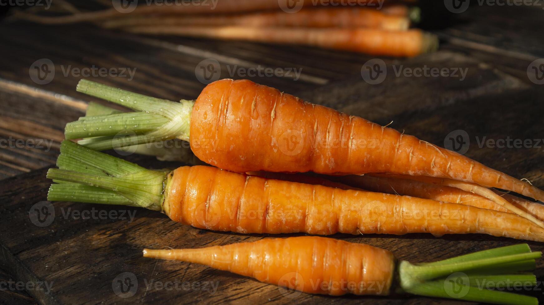 a bunch of carrots sitting on a wooden table photo