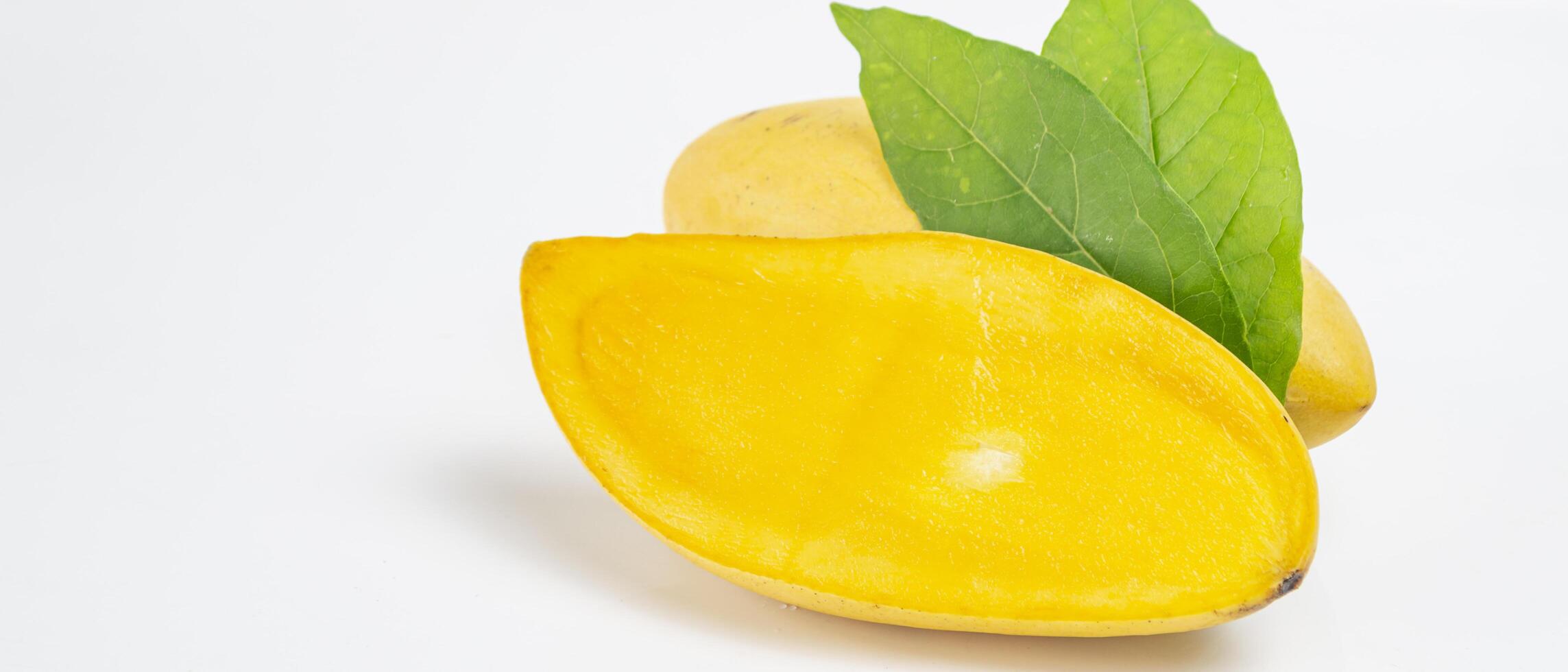 a mango cut half with a leaf on it photo