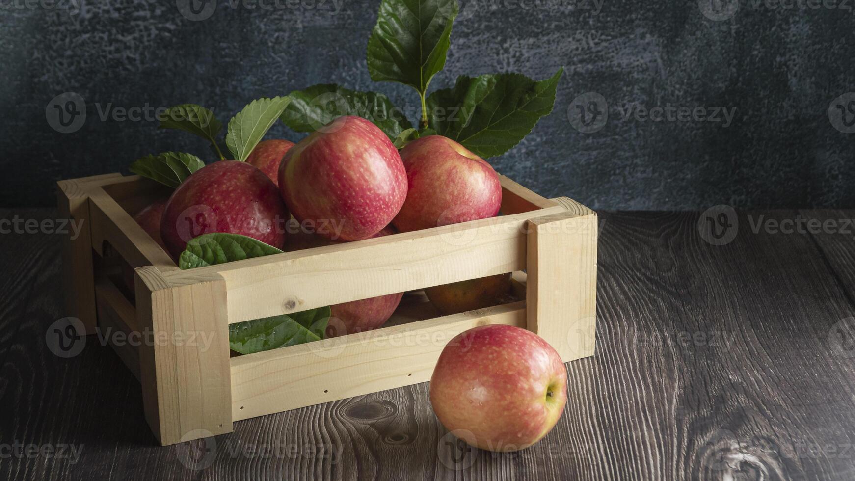 a wooden crate with apples on a table photo