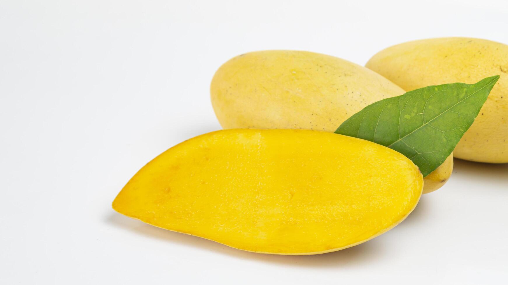 a mango cut half with a leaf on it photo