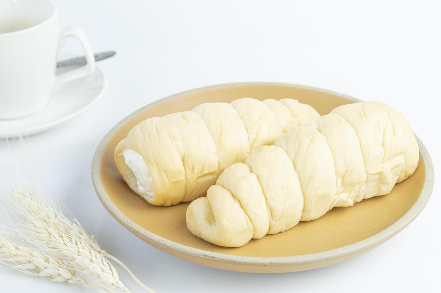 two croissants on a plate with a cup of coffee photo