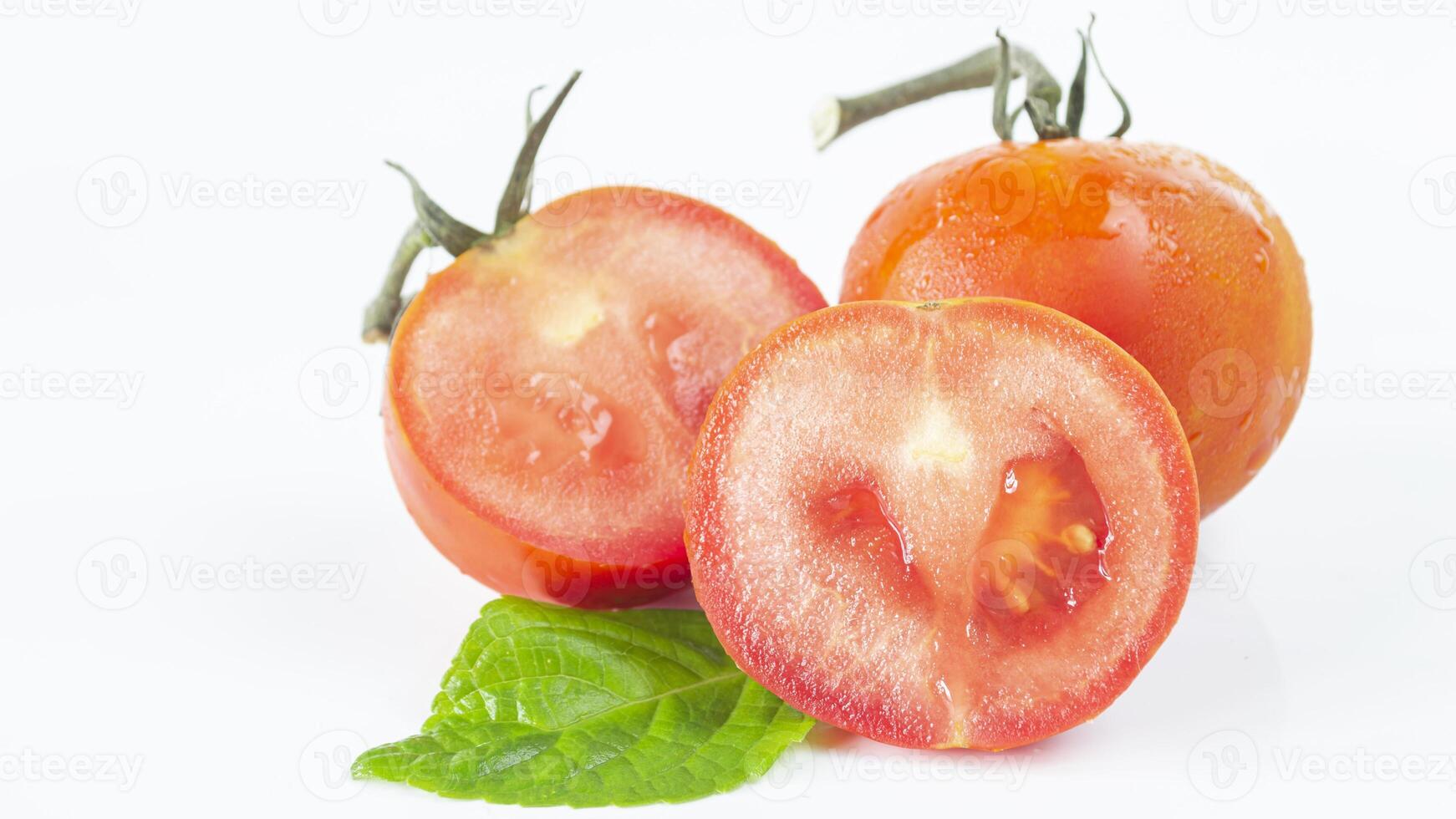 two tomatoes with leaves on a white background photo